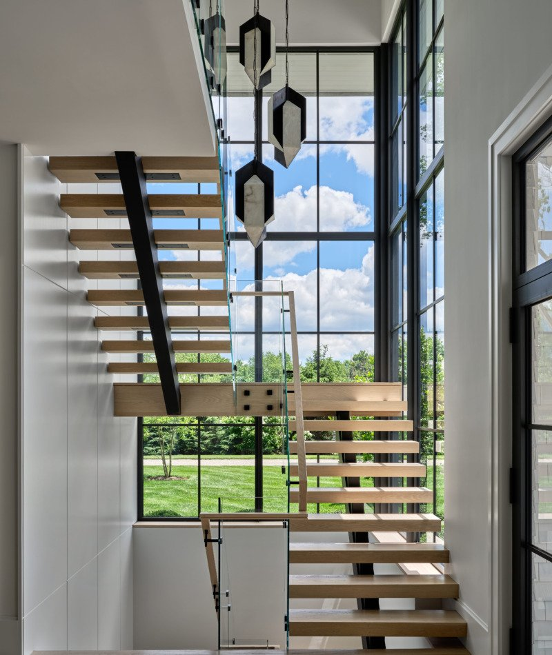 Modern two-storey interior with floor-to-ceiling European aluminum windows and floating staircase