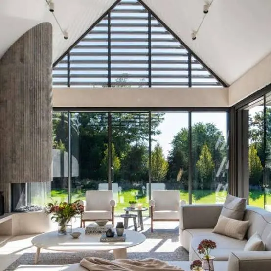Glazed gable extension with slim aluminum frames filling a living room with daylight